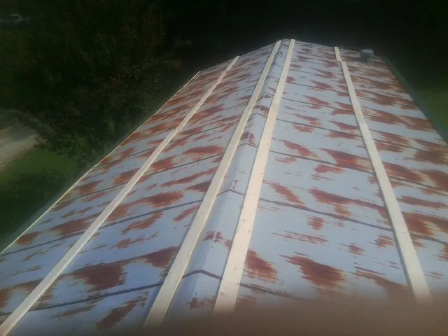 Rusted metal roof panels with new wood purlins before replacement — Storm Damage Roof Repair in Lawrenceburg by Roofing Brothers